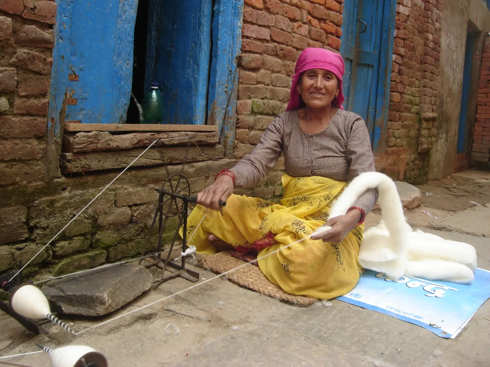 A woman home-based worker of Khokana spinning wool for a carpet factory